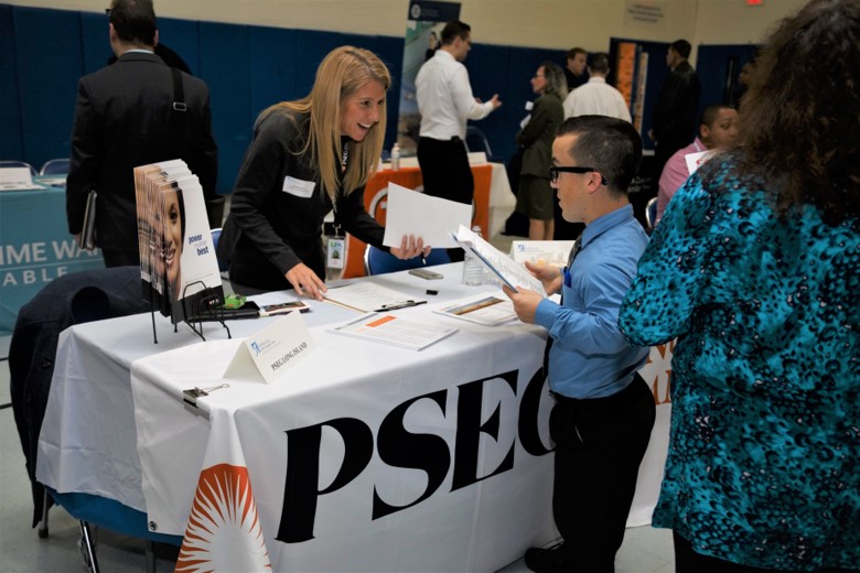 A small group of prospective employers and employees at a career fair table for PSEG